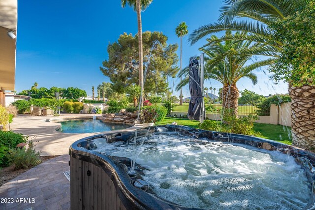 view of swimming pool with a patio and a hot tub