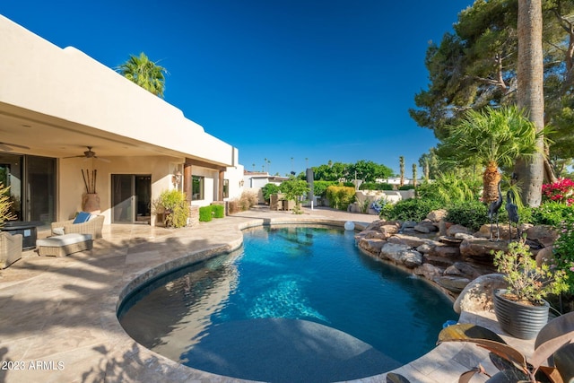 view of swimming pool featuring ceiling fan and a patio area