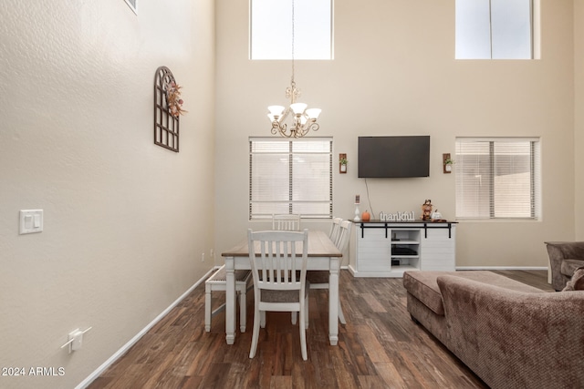 dining area with a high ceiling, a notable chandelier, and dark wood-type flooring