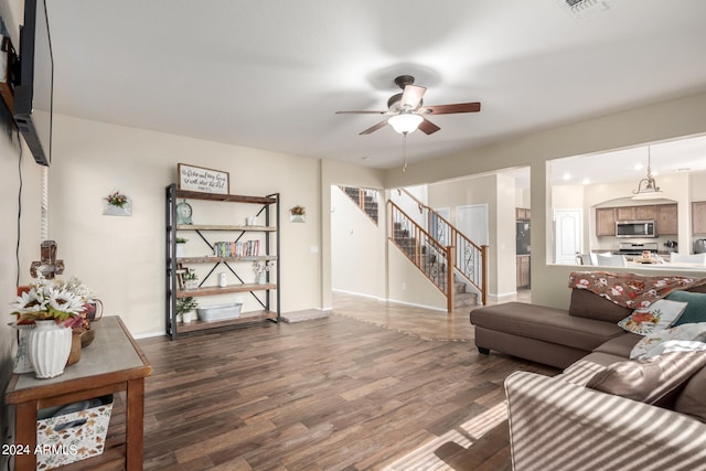 living room featuring ceiling fan and dark wood-type flooring