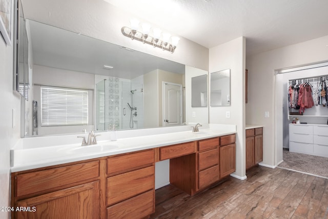 bathroom featuring wood-type flooring, vanity, and an enclosed shower