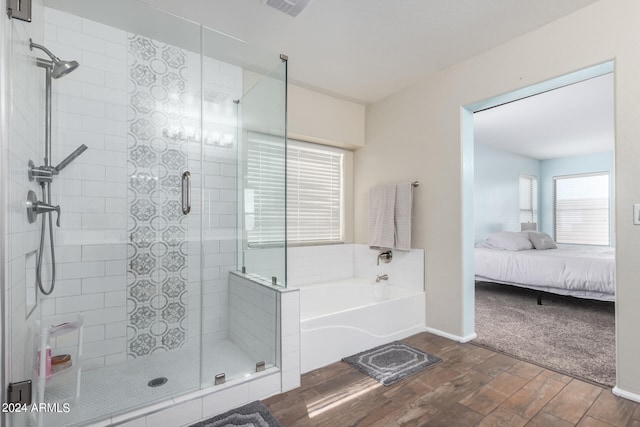 bathroom with hardwood / wood-style flooring and independent shower and bath