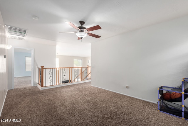 carpeted spare room with ceiling fan