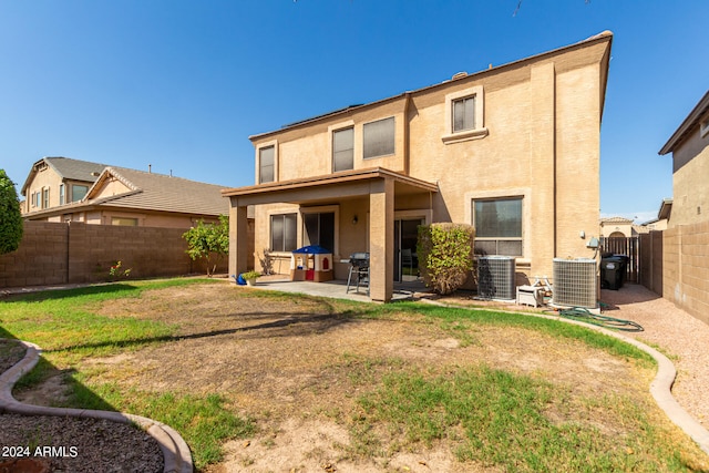 rear view of house with a patio, central AC unit, and a lawn