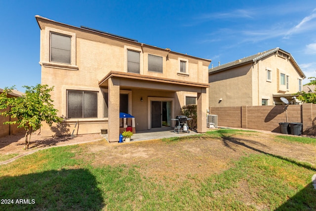 back of property with a yard, central AC, and a patio area