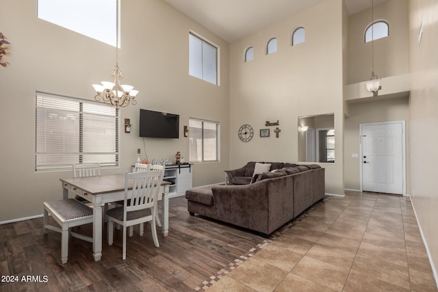 dining space with light wood-type flooring, plenty of natural light, and a high ceiling