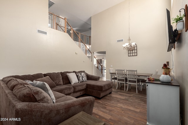 living room featuring a high ceiling, a notable chandelier, and dark wood-type flooring