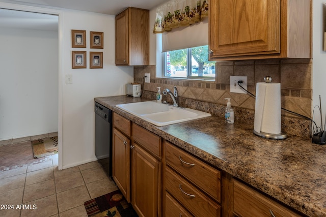 kitchen featuring decorative backsplash, light tile patterned floors, black dishwasher, and sink