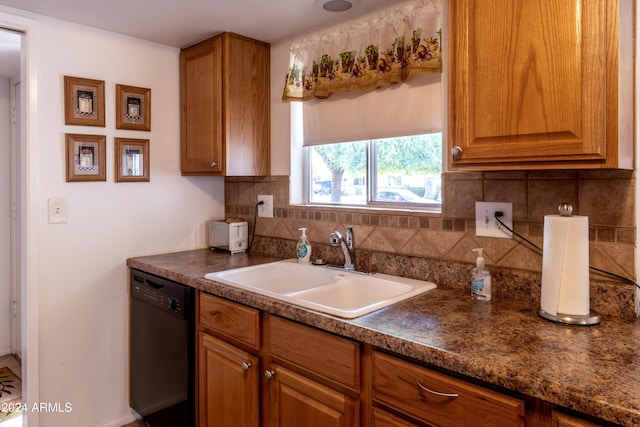 kitchen featuring dishwasher, decorative backsplash, and sink