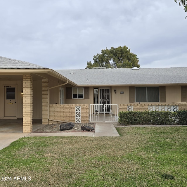 single story home with a front yard and a carport