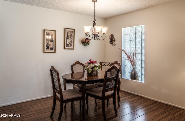 dining room featuring a textured ceiling, a notable chandelier, and dark wood-type flooring