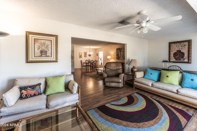 living room featuring ceiling fan with notable chandelier, wood-type flooring, and a textured ceiling