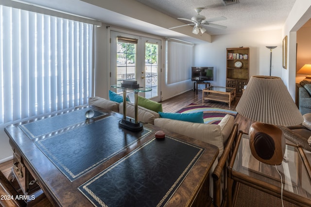 living room featuring ceiling fan, french doors, a textured ceiling, and hardwood / wood-style flooring