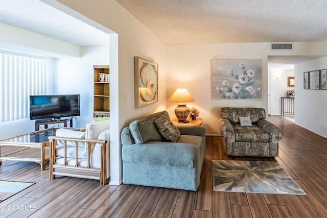 living room featuring wood-type flooring and a textured ceiling