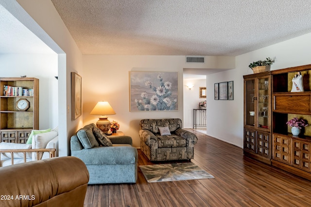 living room with dark hardwood / wood-style flooring and a textured ceiling