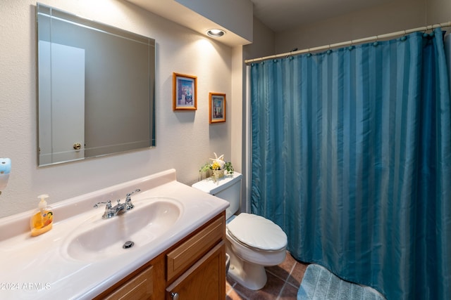 bathroom featuring tile patterned flooring, vanity, and toilet