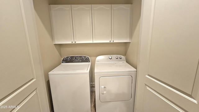 clothes washing area featuring cabinets and washer and dryer