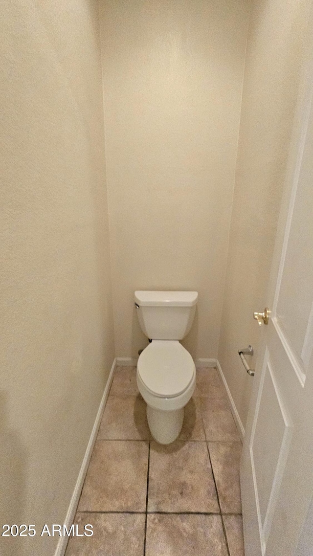 bathroom featuring toilet and tile patterned flooring