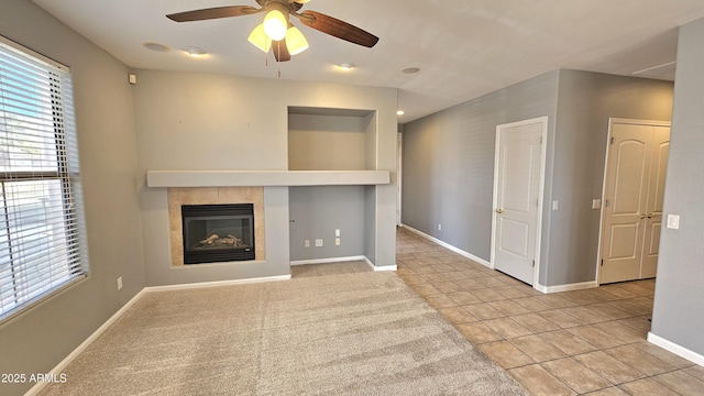 unfurnished living room with ceiling fan, light tile patterned floors, and a fireplace