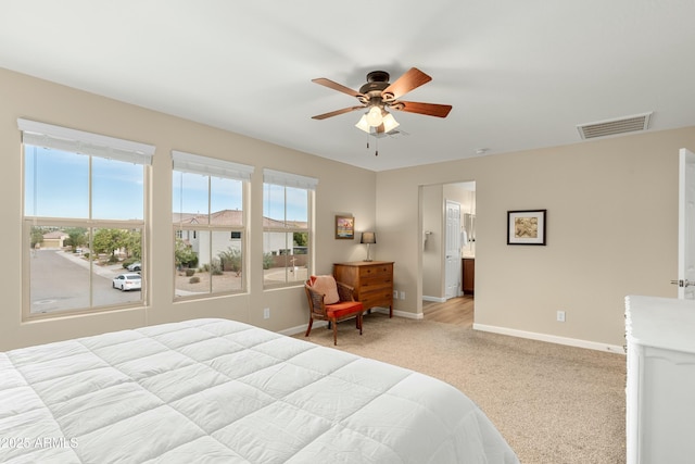 carpeted bedroom with ceiling fan and ensuite bath