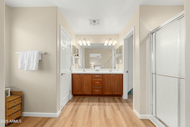 bathroom featuring vanity, wood-type flooring, and walk in shower