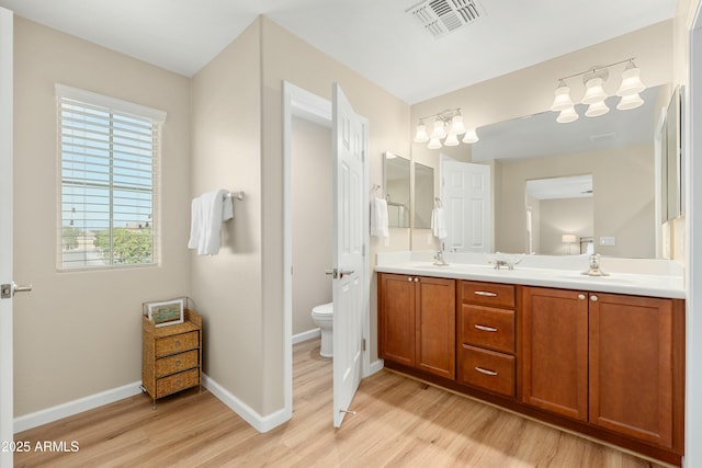 bathroom featuring hardwood / wood-style flooring, vanity, and toilet