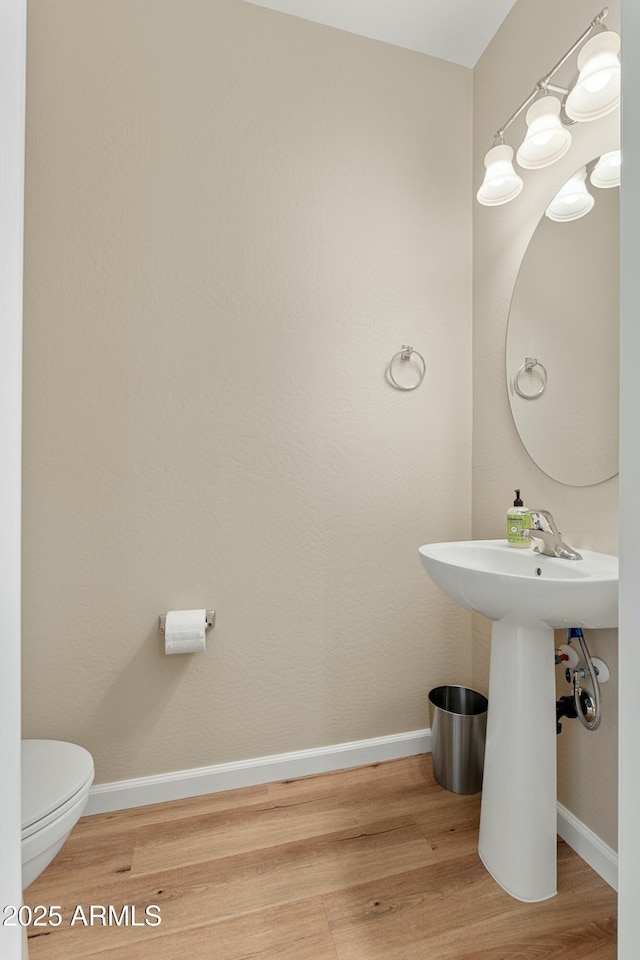 bathroom featuring hardwood / wood-style flooring and toilet