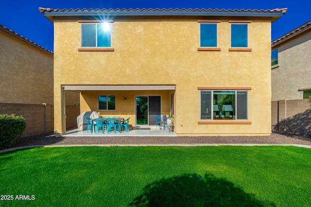 back of property featuring a lawn and a patio