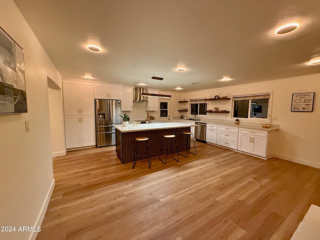 kitchen with pendant lighting, white cabinets, stainless steel appliances, a center island, and a breakfast bar area