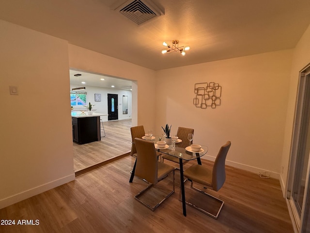 dining room featuring hardwood / wood-style flooring and a chandelier