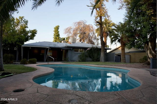 view of pool featuring a patio and central AC unit