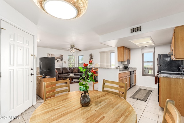 tiled dining space featuring ceiling fan and sink