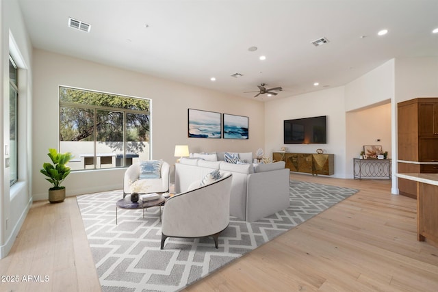 living room featuring light hardwood / wood-style flooring and ceiling fan