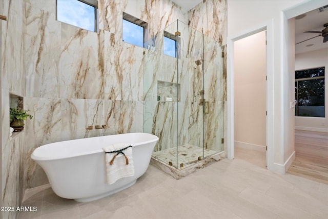 bathroom featuring plus walk in shower, tile walls, and ceiling fan