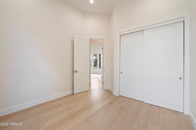 unfurnished bedroom with light hardwood / wood-style flooring and a closet