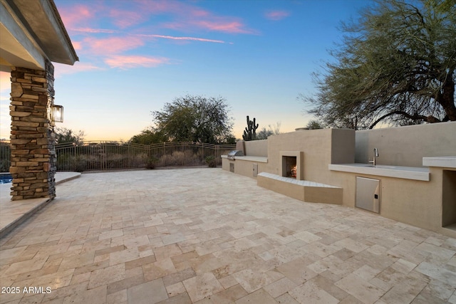 patio terrace at dusk featuring area for grilling