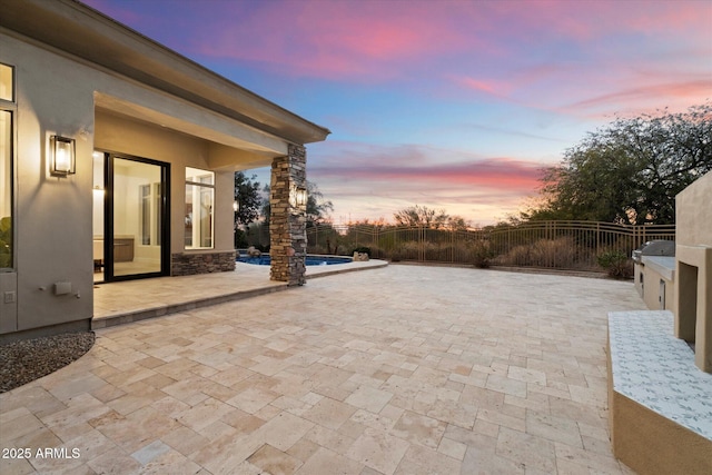 patio terrace at dusk featuring a fenced in pool