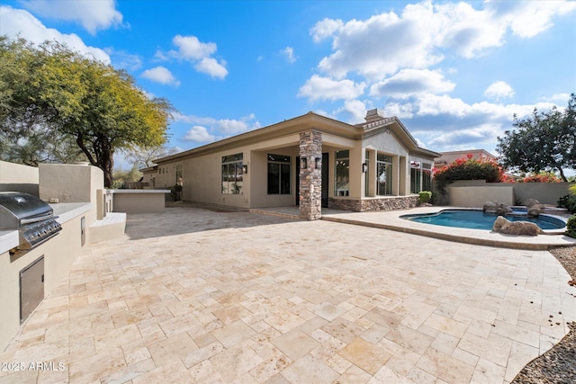 back of house with a fenced in pool, area for grilling, and a patio area