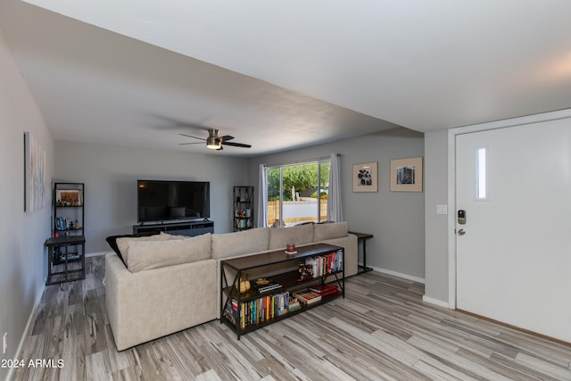 living room featuring ceiling fan and light hardwood / wood-style flooring