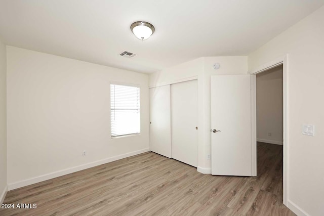 unfurnished bedroom featuring light hardwood / wood-style flooring and a closet