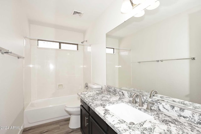 full bathroom featuring toilet, hardwood / wood-style flooring, vanity, and shower / bathtub combination