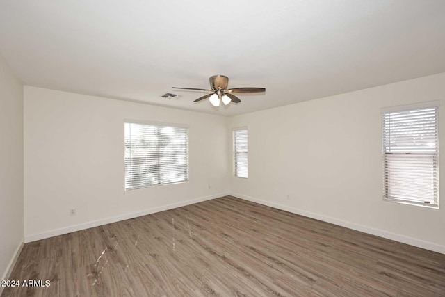 spare room featuring a healthy amount of sunlight, hardwood / wood-style flooring, and ceiling fan