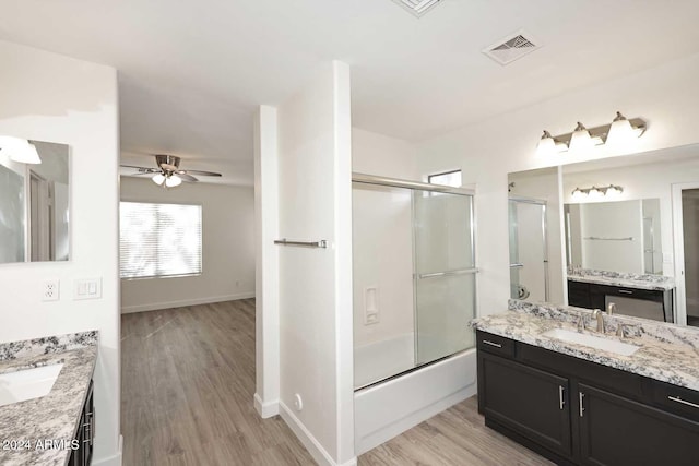 bathroom featuring vanity, combined bath / shower with glass door, hardwood / wood-style flooring, and ceiling fan