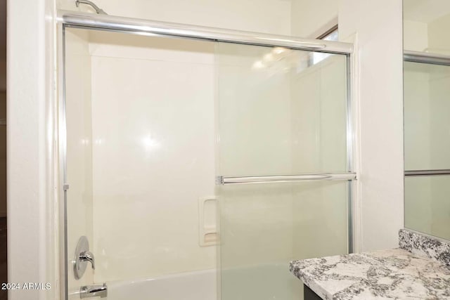 bathroom with vanity and bath / shower combo with glass door