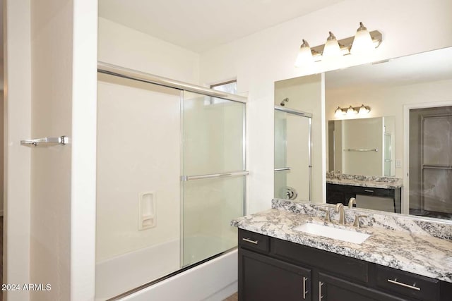 bathroom featuring vanity and shower / bath combination with glass door