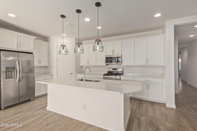 kitchen with light wood-type flooring, stainless steel appliances, white cabinetry, and sink