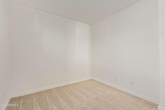 unfurnished room featuring carpet and lofted ceiling