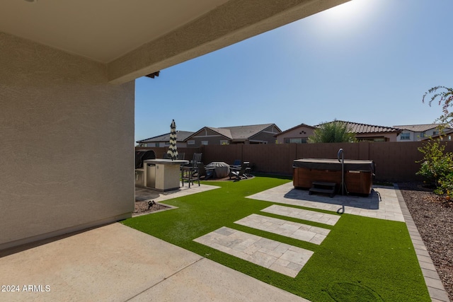 view of yard with a patio, an outdoor kitchen, and a hot tub