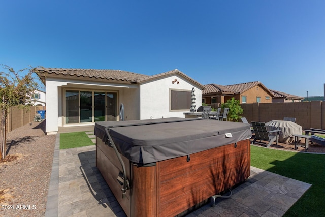 exterior space with a hot tub and a patio area