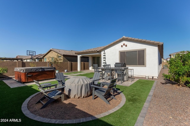 rear view of property with a yard, a patio, and a hot tub